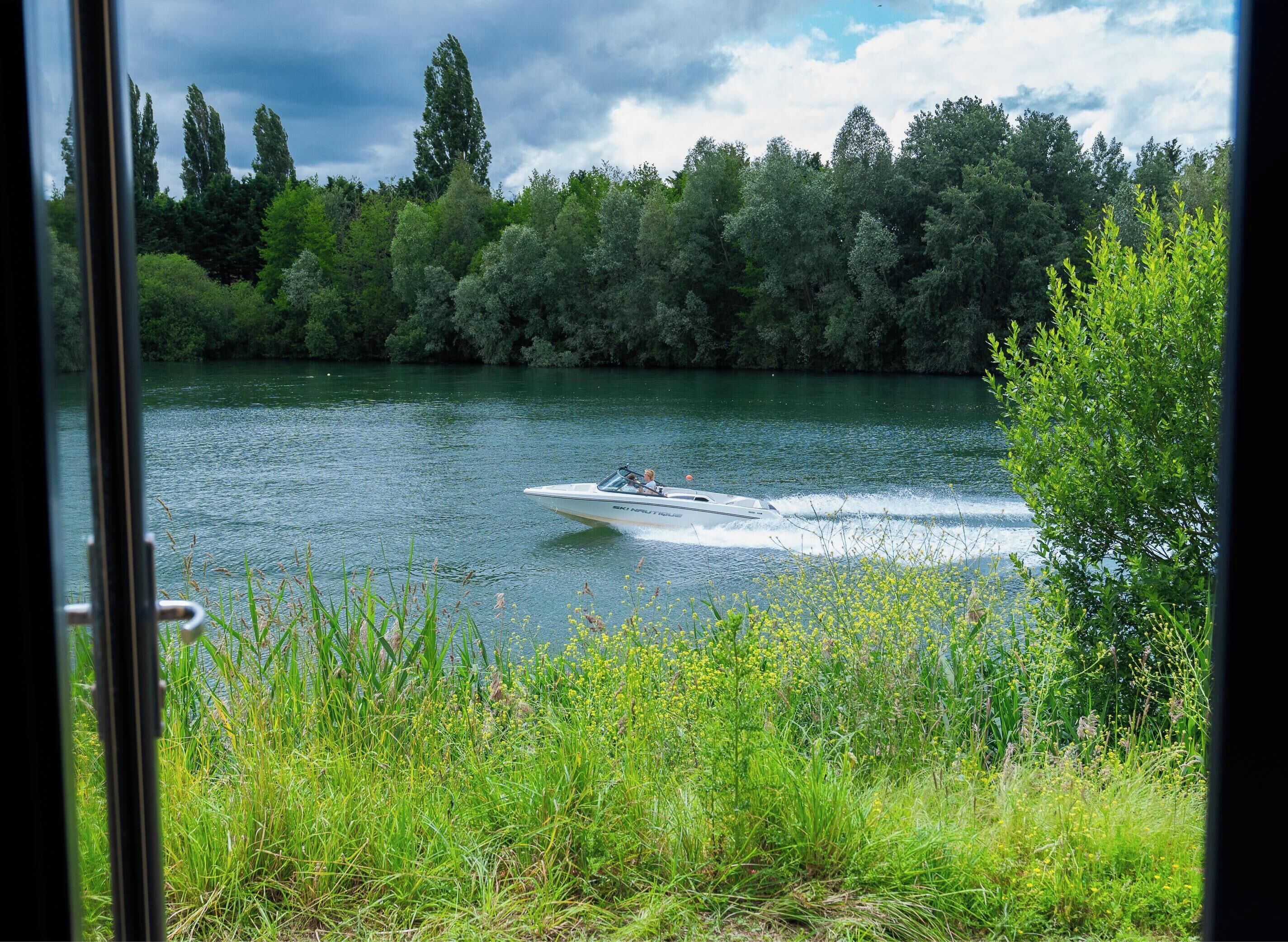 A boat on a river with a forested area in the background.