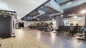 A gym with exercise equipment, weight racks, and a wooden floor. - Maison Privee - Stunning Waterfront Apt w/ Open Sea Vws in La Mer (Dubai)