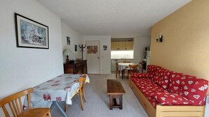 A compact living space with a dining area, a sofa, a small table, and a kitchenette. - Apartment 6 ppl, south balcony, near cross-country ski slopes (Autrans-Méaudre en Vercors-Autrans)