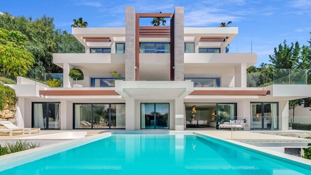 A modern multi-story house with a swimming pool, large windows, and outdoor seating. - Villa Alejandra (Benahavís)