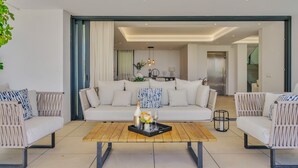 A modern living room with a sofa set, a coffee table, and a dining area. - Villa Alejandra (Benahavís)