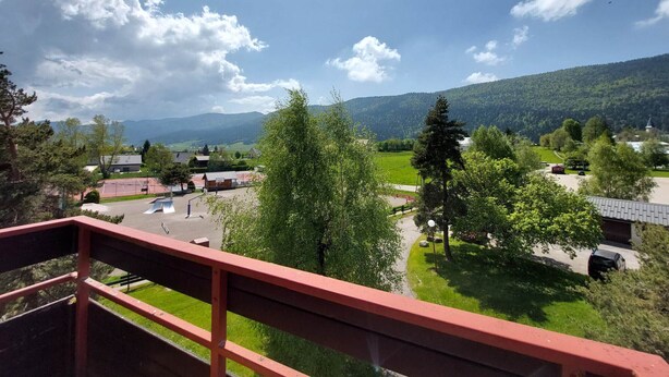 A balcony with a red railing overlooking a green landscape with trees and a clear sky. - Beautiful duplex for 6, slopeside with parking (Autrans-Méaudre en Vercors-Autrans)