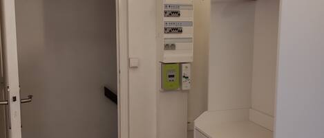 Un placard blanc avec des cintres en bois et une commode blanche.