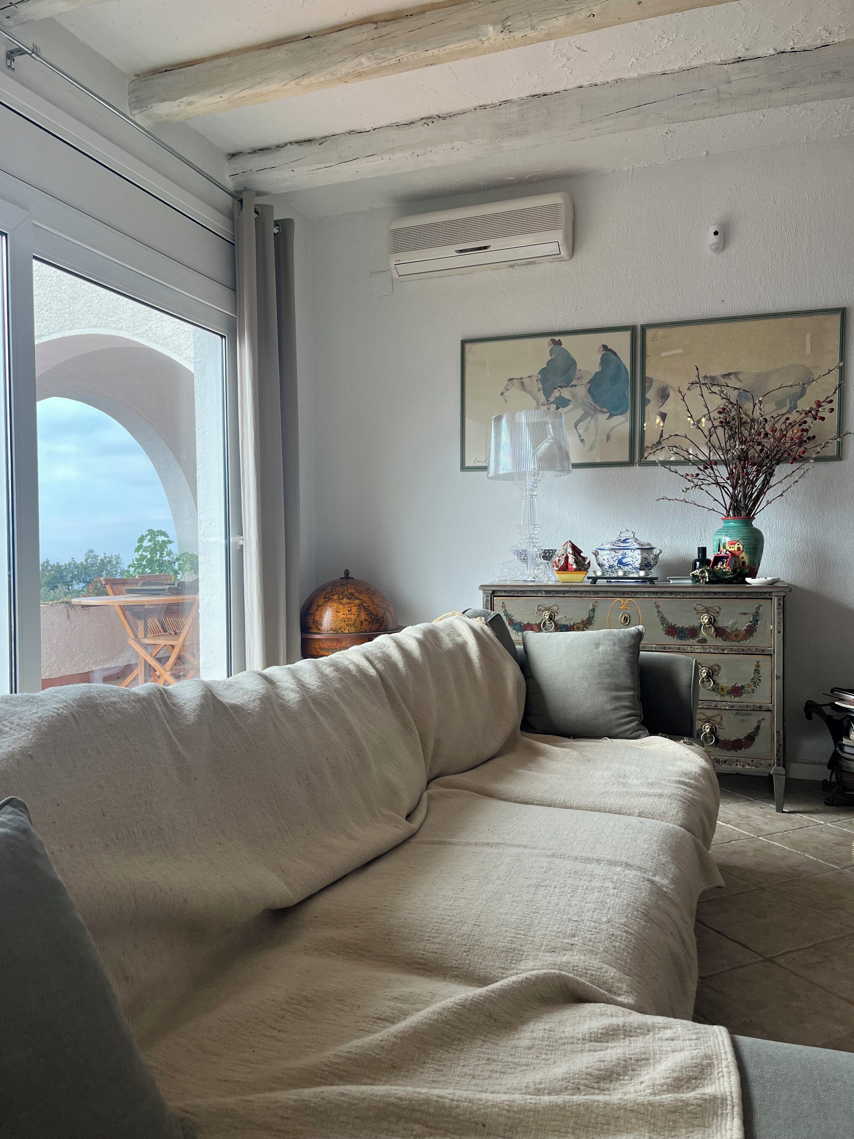 Un salón acogedor con un sofá, un globo terráqueo y objetos decorativos.