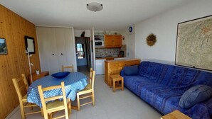 A compact living space with a dining area, kitchenette, and a sofa. - Charming apartment in Méaudre - 5 pers, parking included (Méaudre)