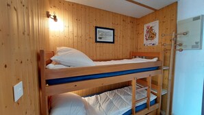 A bunk bed room with wooden walls, a framed picture, and a poster. - Charming apartment in Méaudre - 5 pers, parking included (Méaudre)