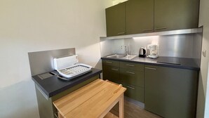 Una cocina compacta equipada con cafetera, hervidor y tostadora.