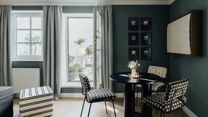 A dining area with a round table, chairs, and a view of the outdoors.