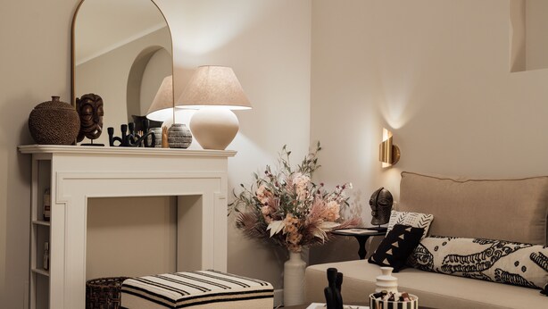 A living room with a fireplace, a sofa, a coffee table, and a lamp.