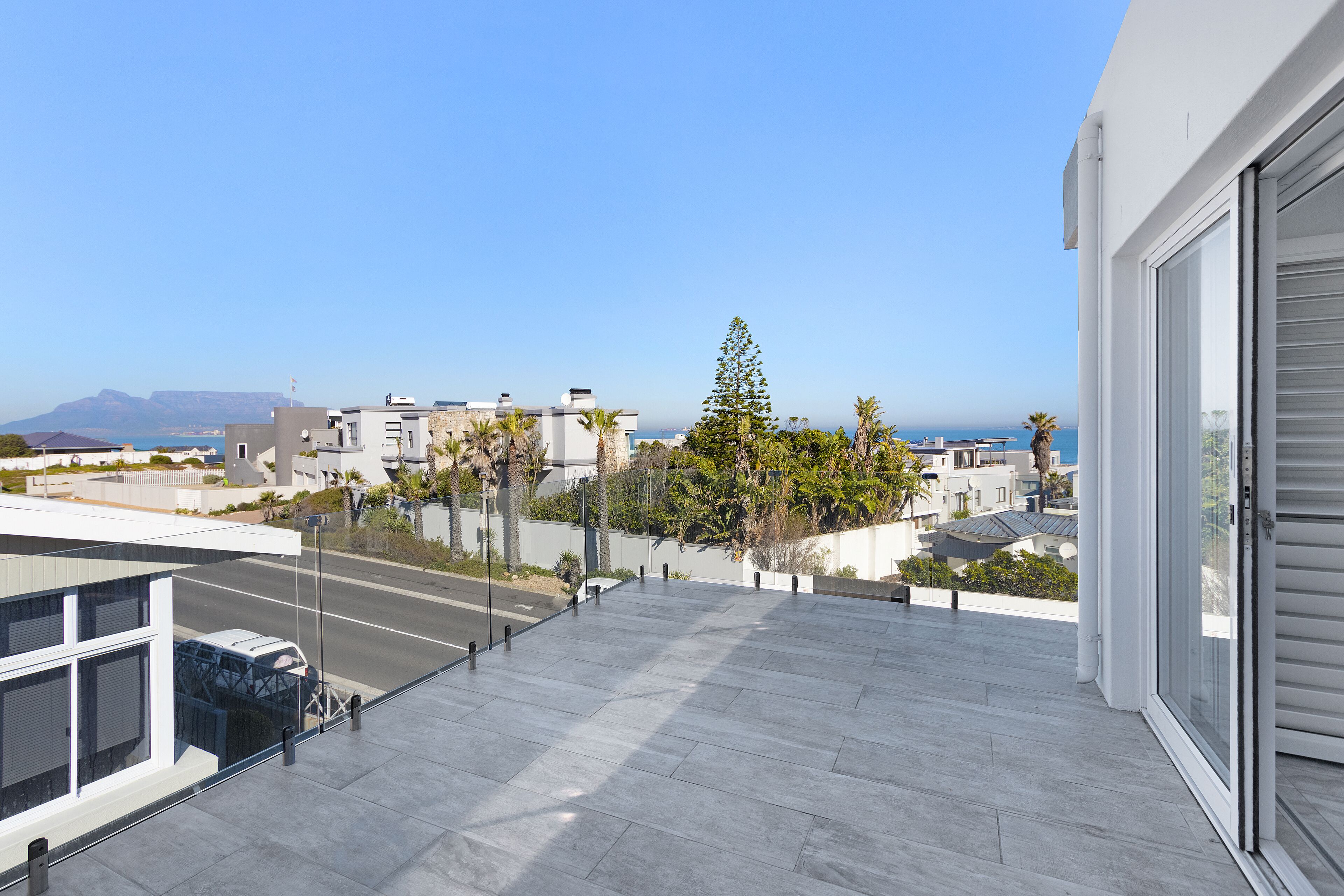 A balcony with a view of the city and mountains.
