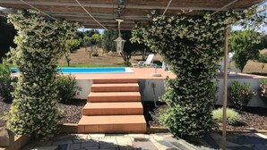 A covered outdoor area with steps leading to a pool, surrounded by greenery and a clear view of the pool in the background. - Maison 5 Chambres, Piscine Partagée-plage à 2.5 km (Luz)