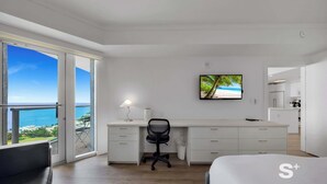 A modern hotel room with a balcony, a desk with a chair, a bed, and a television. - 1-BD Condo in Coconut Grove | Water Views (Miami)