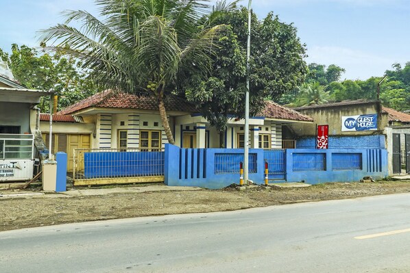 A building with a blue exterior and a sign that reads "MY GUEST HOUSE."