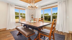 Un coin repas avec une table en bois, des chaises et un lustre.