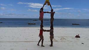 Una playa con cielo despejado y barcos en el agua.