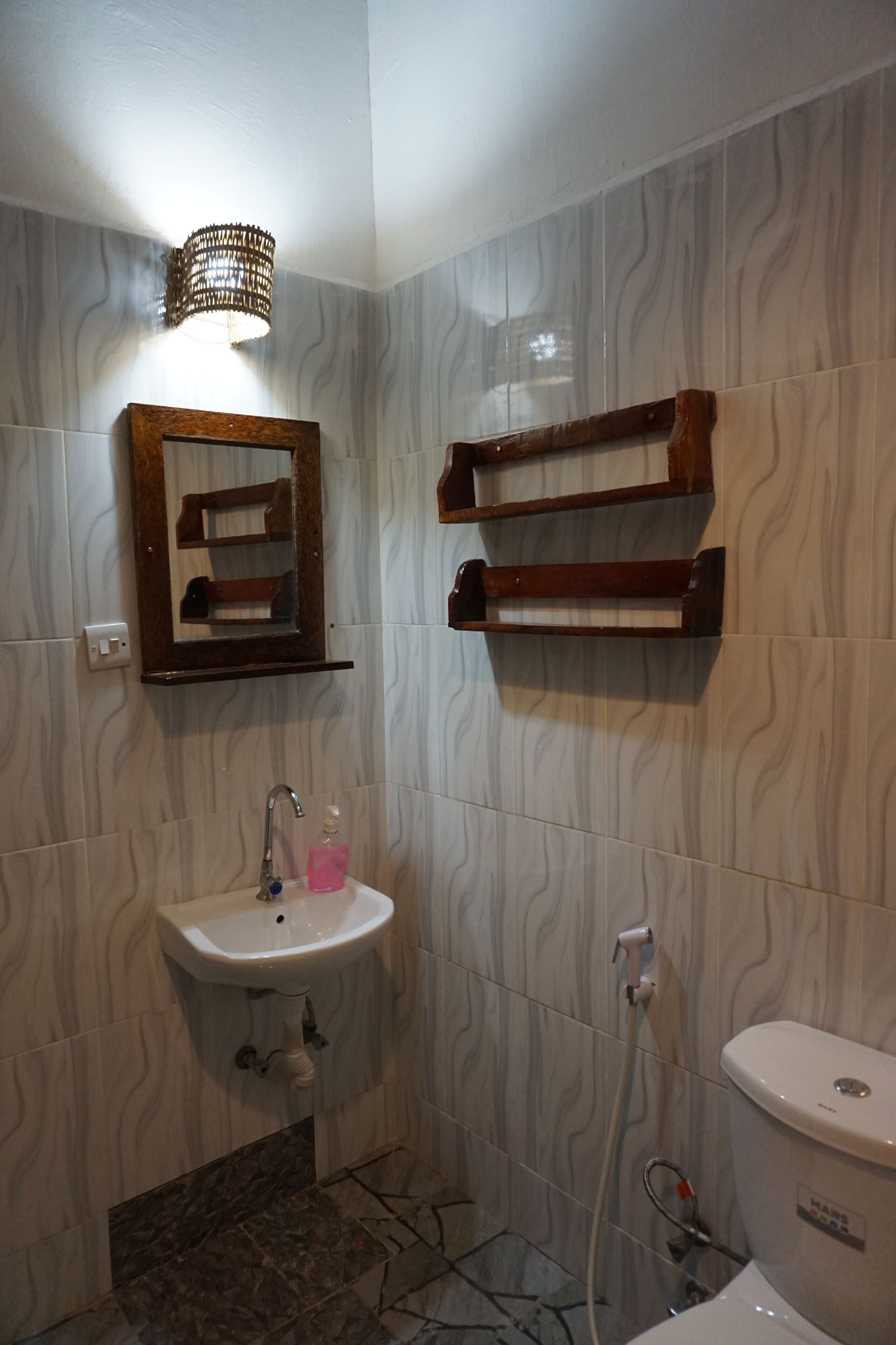 A bathroom with a sink, mirror, towel rack, and toilet.