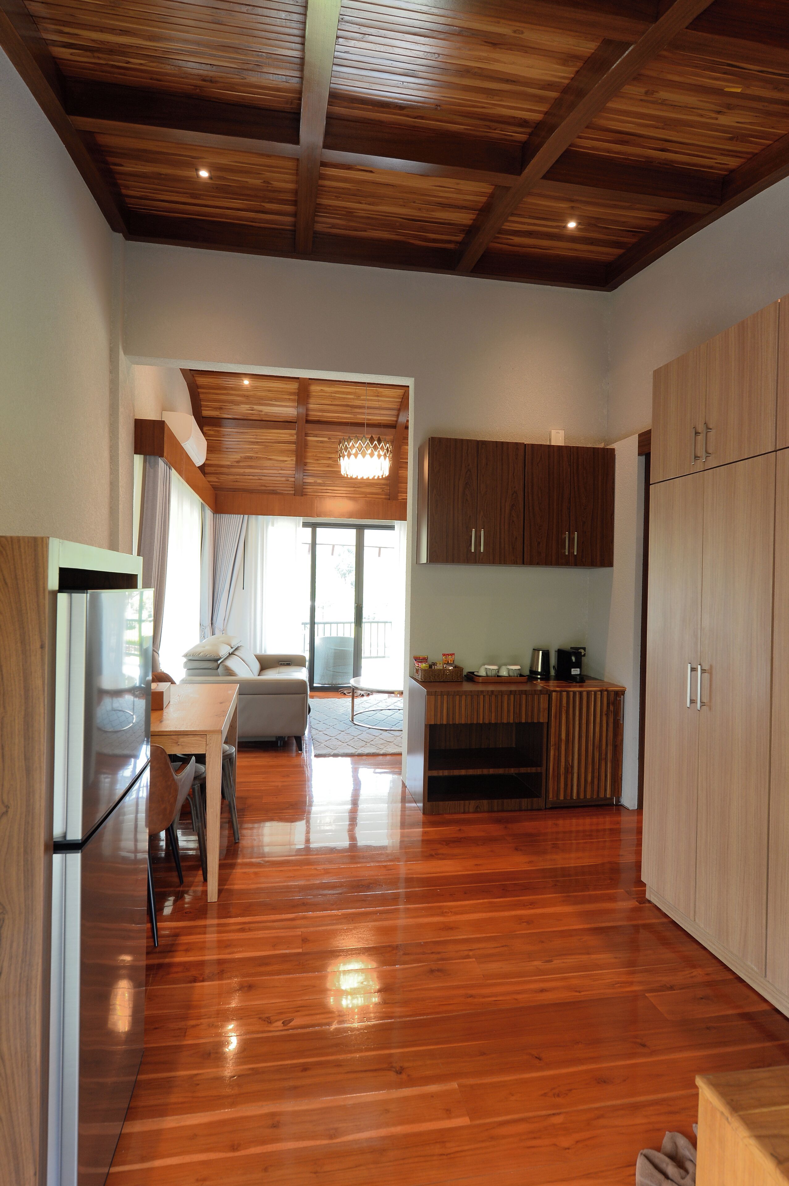 A spacious kitchen with wooden cabinets, a dining area with a table and chairs, and a large window providing natural light.