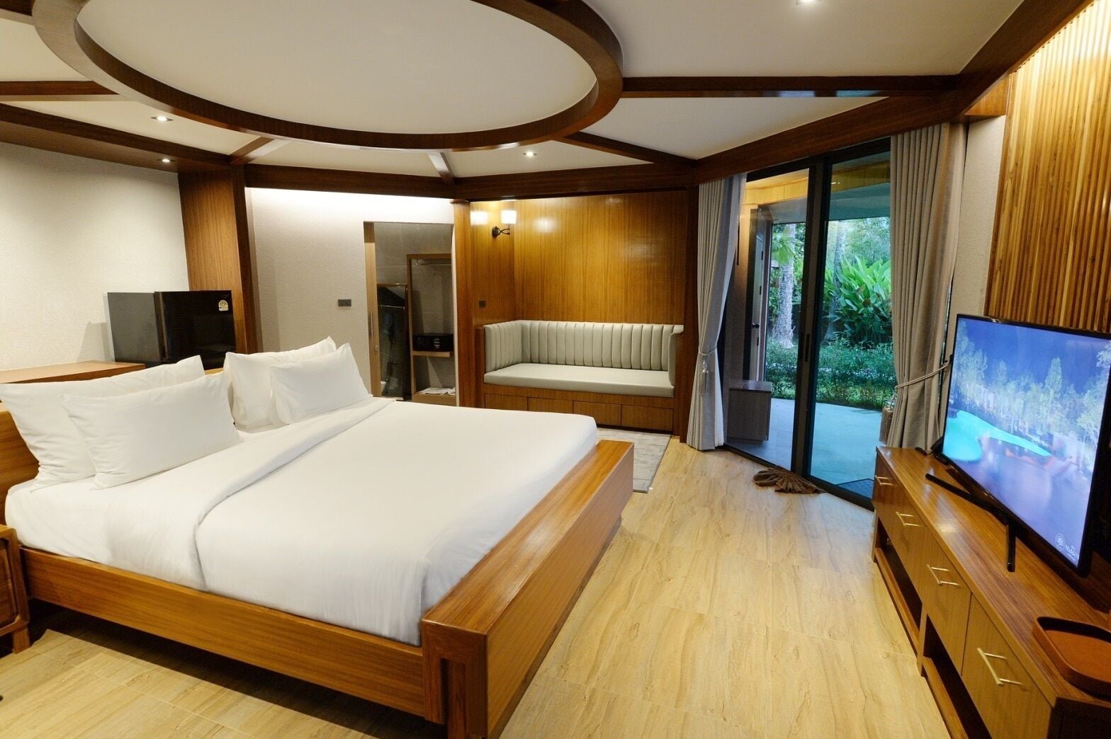 Une chambre d’hôtel moderne dotée d’un grand lit, d’un coin salon et d’une télévision.