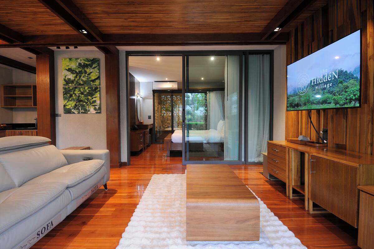 Una sala de estar moderna con un sofá, un televisor y un mueble de madera.