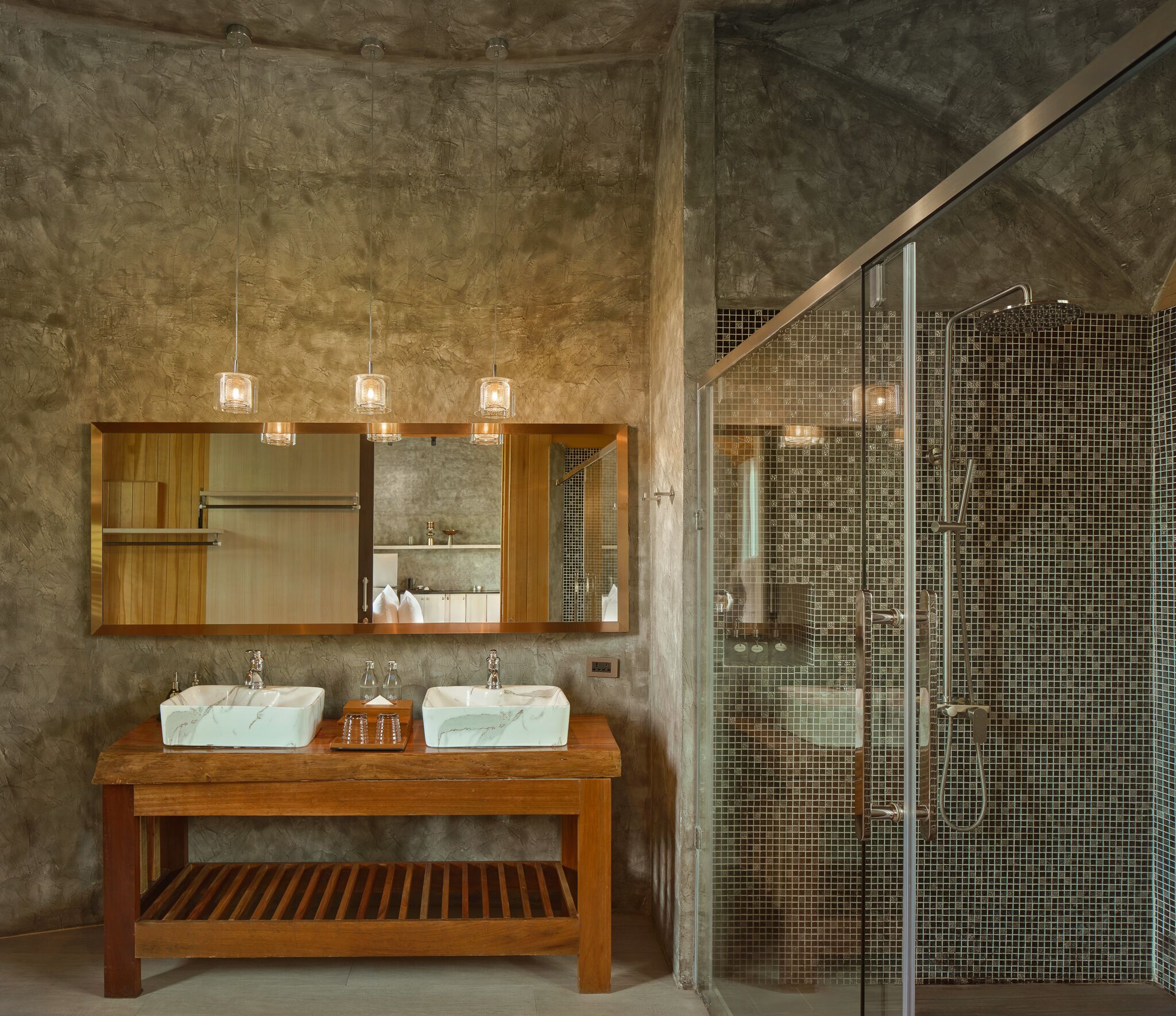Une salle de bain avec un meuble-lavabo en bois, deux vasques, un grand miroir et une douche à parois de verre.