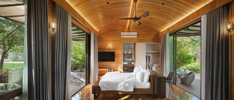 A modern bedroom with a wooden ceiling, a bed, a TV, and a view of the outdoors.