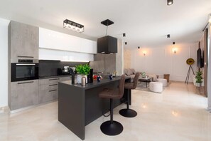Enjoy casual dining and socializing in this sleek kitchen with a central island and appliances.