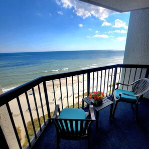 A balcony with a view of the beach and ocean. - Bluetique Oceanfront Studio. Pets are welcome. (Myrtle Beach)