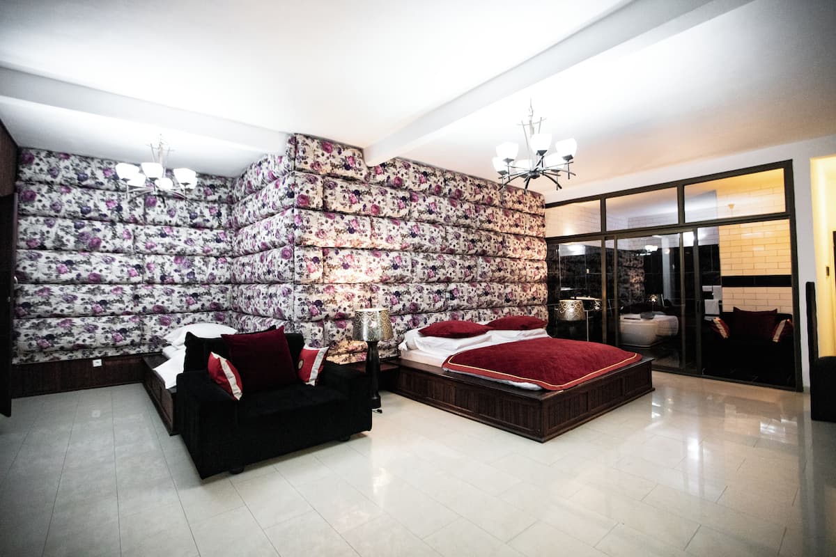 Un dormitorio moderno con una cama grande, un sofá y una pared decorativa.