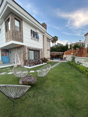 A two-story building with a stone facade and a sign reading "PUPA ALACATI". - Pupa Alacati Butik Otel (Cesme)