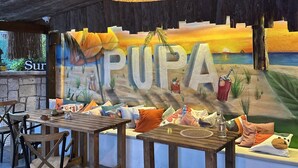 Un interno ristorante con un murale, mobili in legno e un lampadario.