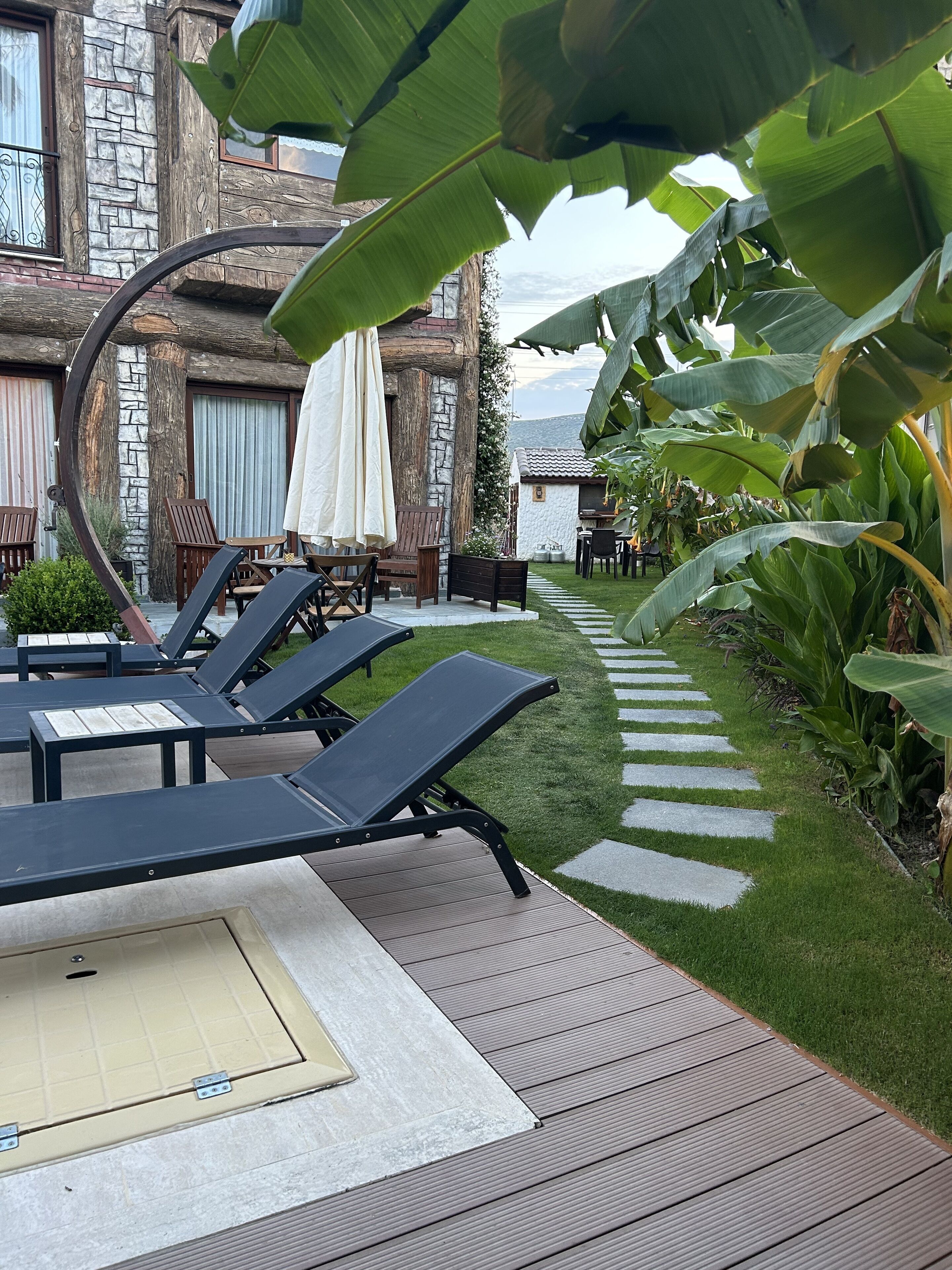 A poolside area with lounge chairs and a stone building in the background.