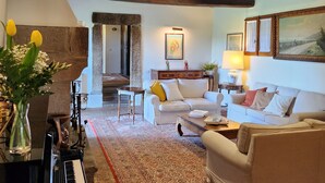 A cozy living room with a piano, sofas, a rug, and a stone fireplace. - 9 Bedroom Private vacation home in Lazio (Lazio)