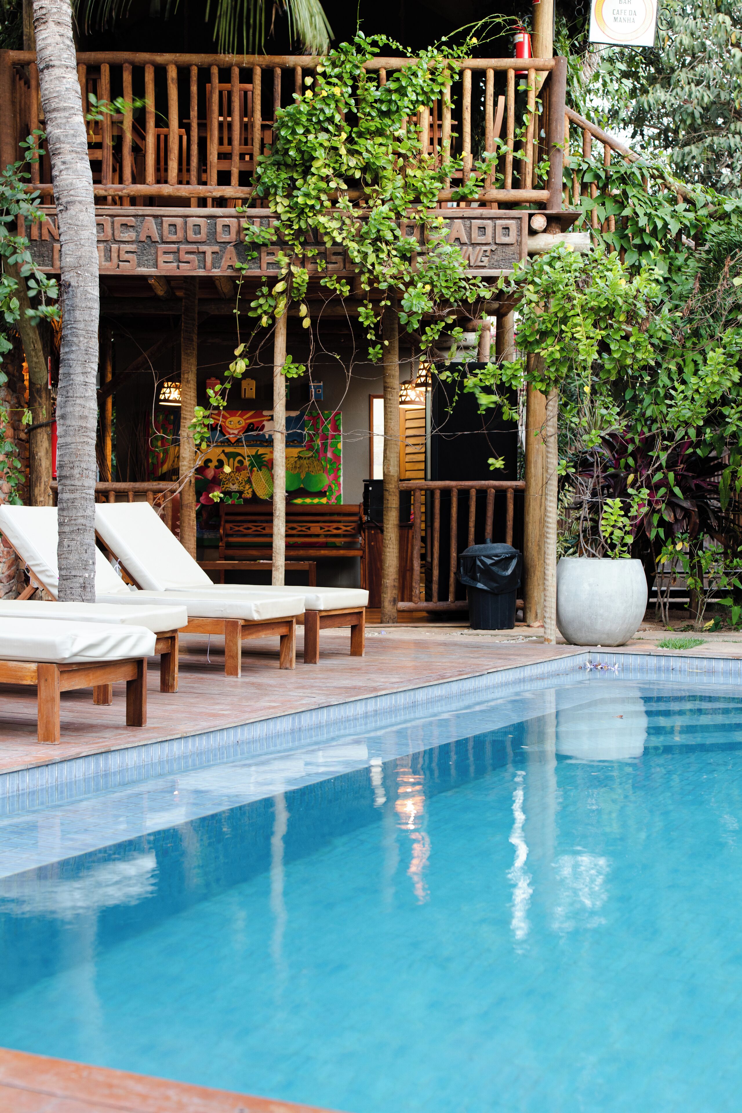 Zona de piscina con sillas de descanso y terraza de madera.