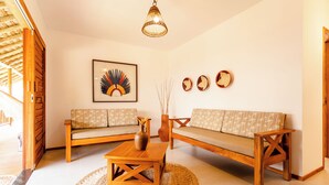 Una sala de estar con dos sofás, una mesa de centro y una lámpara colgante.