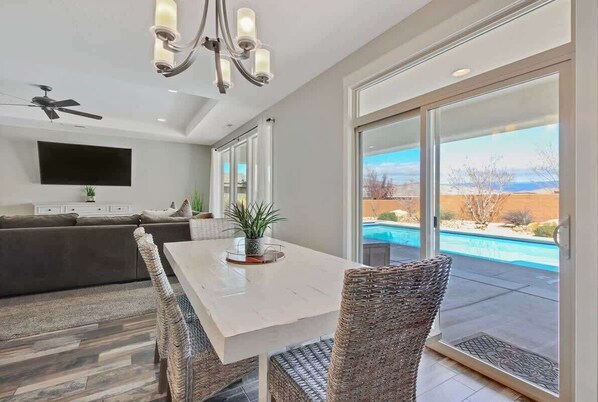 Enjoy meals in a spacious dining area with a table, chairs, and a flat-screen TV.
