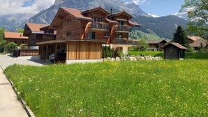 Eine Holzhütte mit Balkon vor einer Bergkulisse.