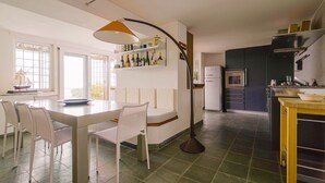 Eine moderne Küche mit Essbereich, ausgestattet mit einem weißen Tisch, Stühlen und einer ungewöhnlichen Stehlampe.