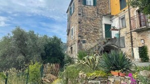 A stone building with a balcony and a garden in front. - Casa Ferrando by Interhome (Torrazza)