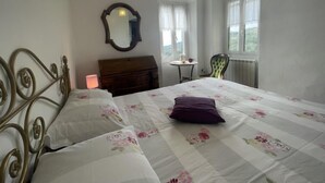 A bedroom with a bed, a dresser, a chair, a table, and a window. - Casa Ferrando by Interhome (Torrazza)
