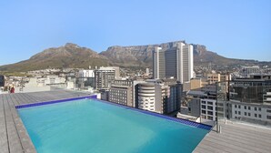 A rooftop pool with a cityscape and mountains in the background. - The Tokyo 807 (Cape Town)