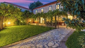 Un edificio de dos pisos con un camino de piedra que conduce a un patio.