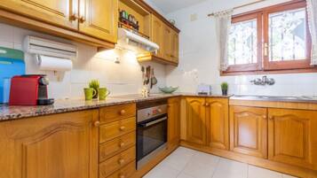 Een koelkast, een magnetron, een oven, kookgerei, borden en bestek