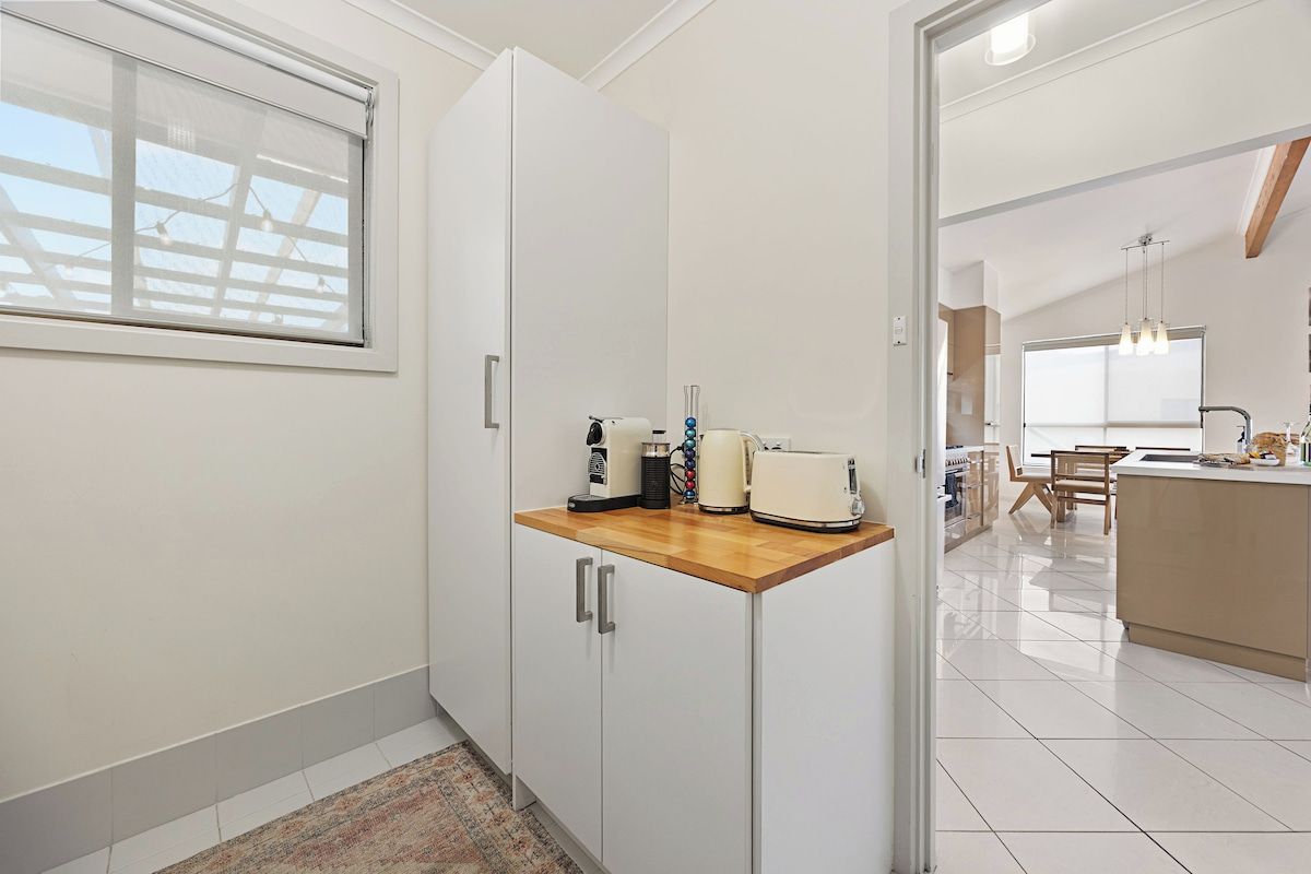 Functional laundry area with additional bench space, storage and small appliance setup, designed to make longer stays and family trips more convenient.