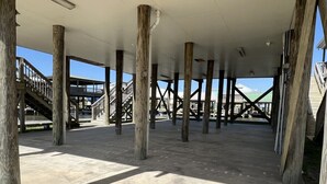 An open, spacious area with concrete flooring and wooden pillars supporting the structure.