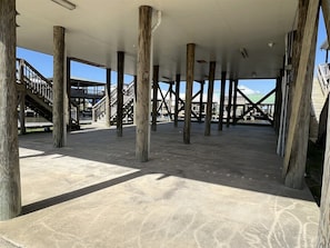 An open, spacious area with concrete flooring and wooden pillars supporting the structure. - Point Fourchon Unit D (Golden Meadow)