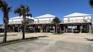 A waterfront building with a covered walkway and a parking area. - Point Fourchon Unit D (Golden Meadow)