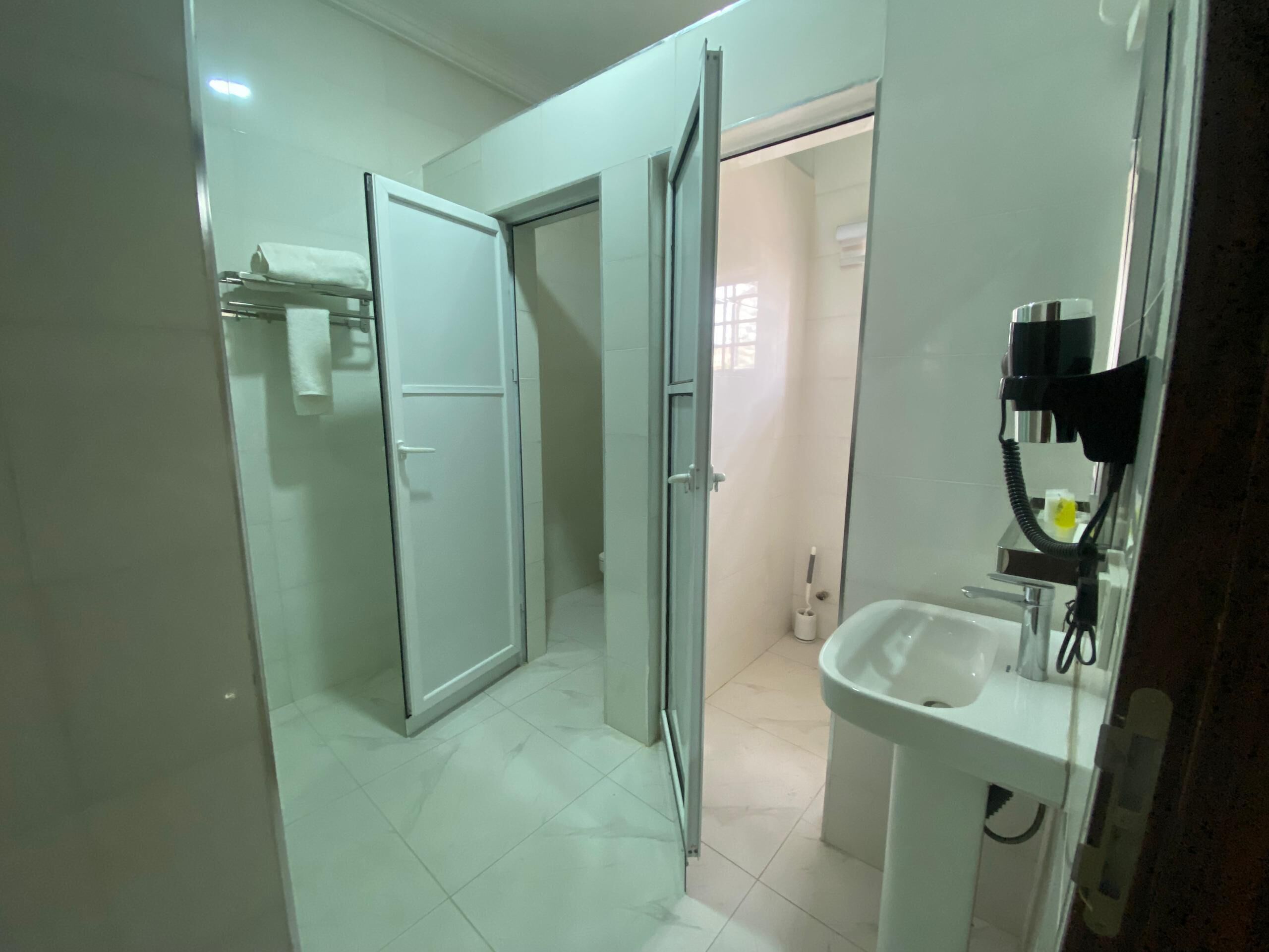 A modern bathroom with a glass shower enclosure, a white sink, and a handheld showerhead.