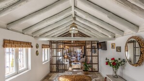 A rustic interior with exposed wooden beams, a large mirror, and a view into a dining area. - MAJADA DEL CONDE (La Guardia)