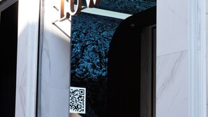 A hotel entrance with a prominent sign reading 'LUIAN' and a QR code.