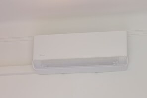 A white air conditioning unit mounted on a wall.